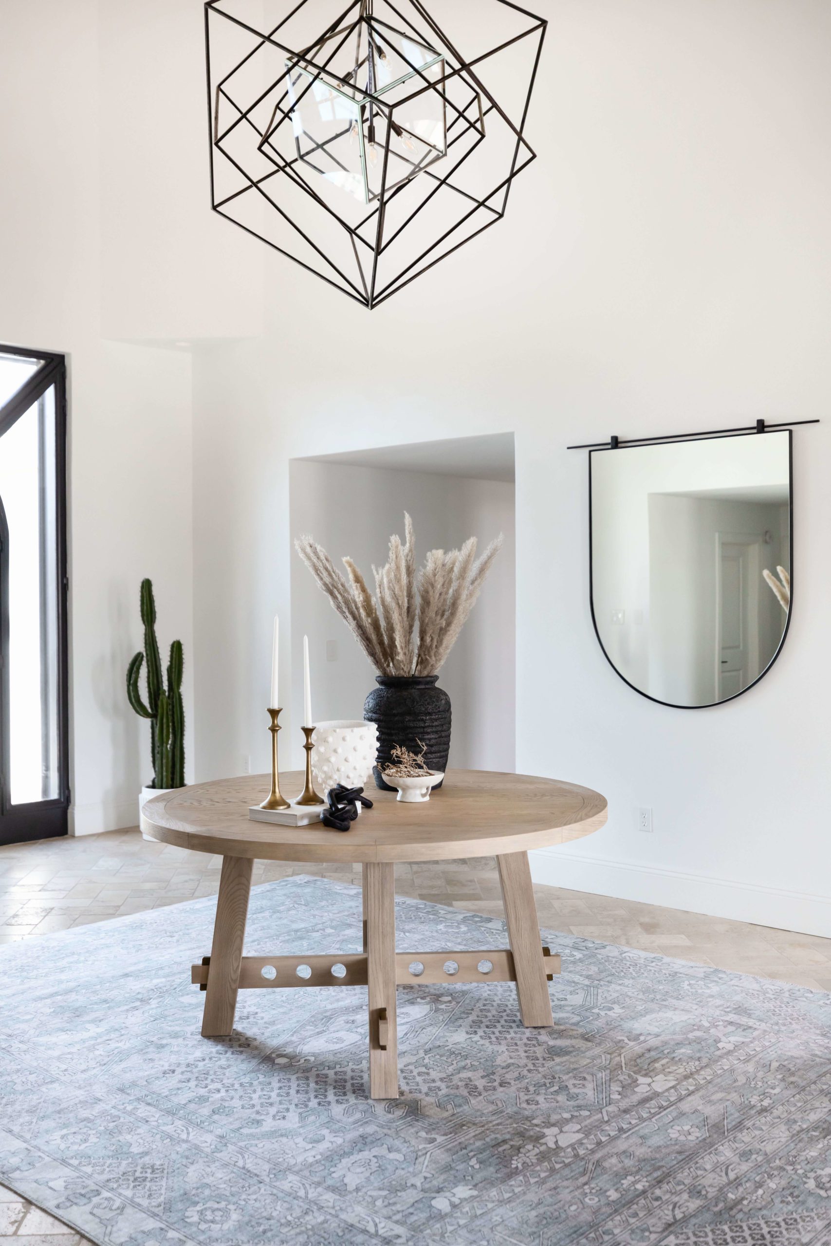 Minimalist entryway with round wooden table and modern geometric light