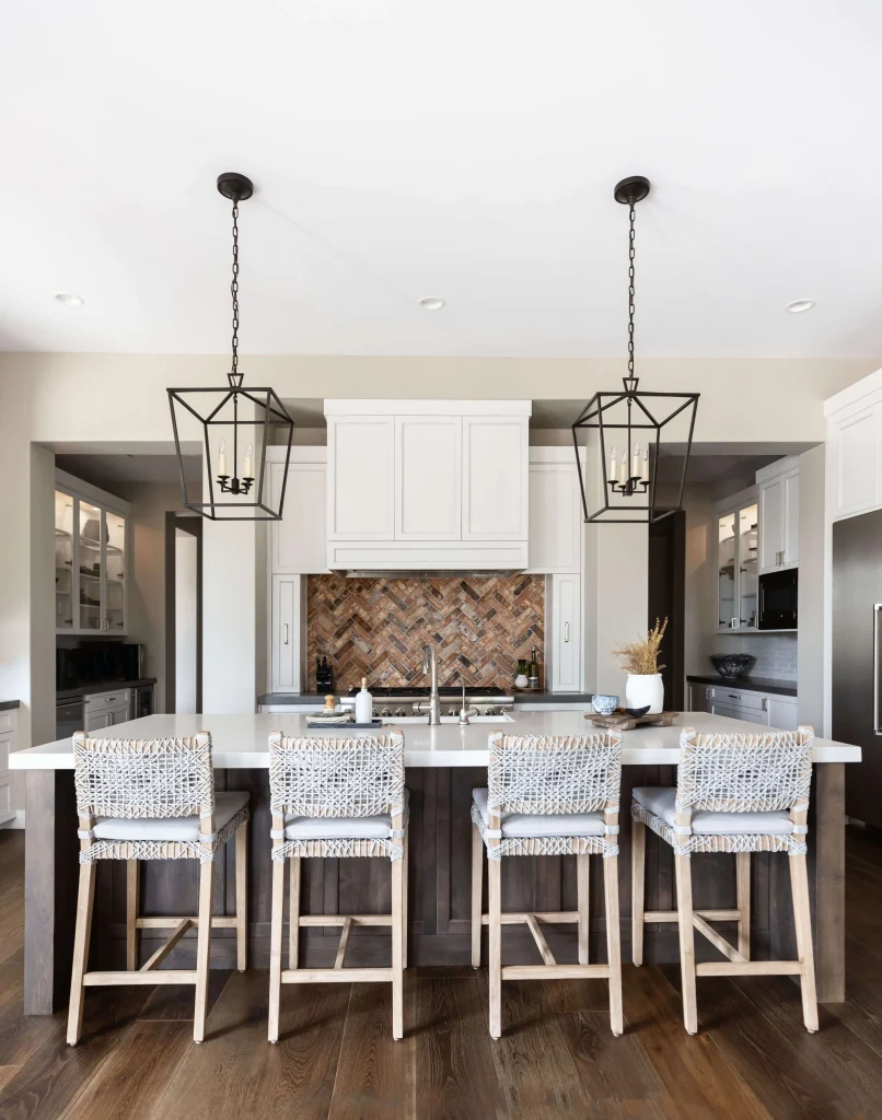 Kitchen island with wicker stools and pendant lights
