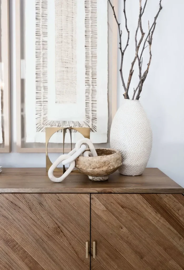 Natural decor with textured vase, bowl, and chain on wooden cabinet