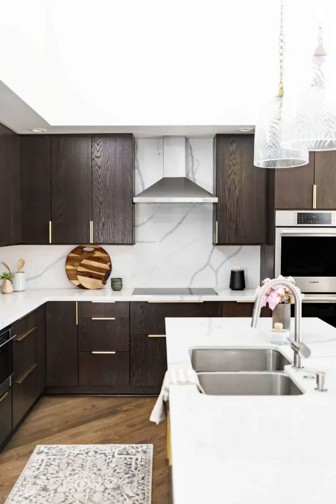 Kitchen with dark cabinets and marble backsplash.