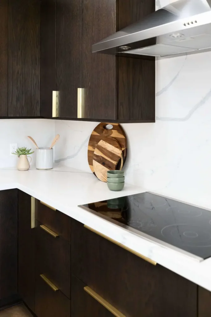 Dark wood kitchen cabinets with white marble countertop.