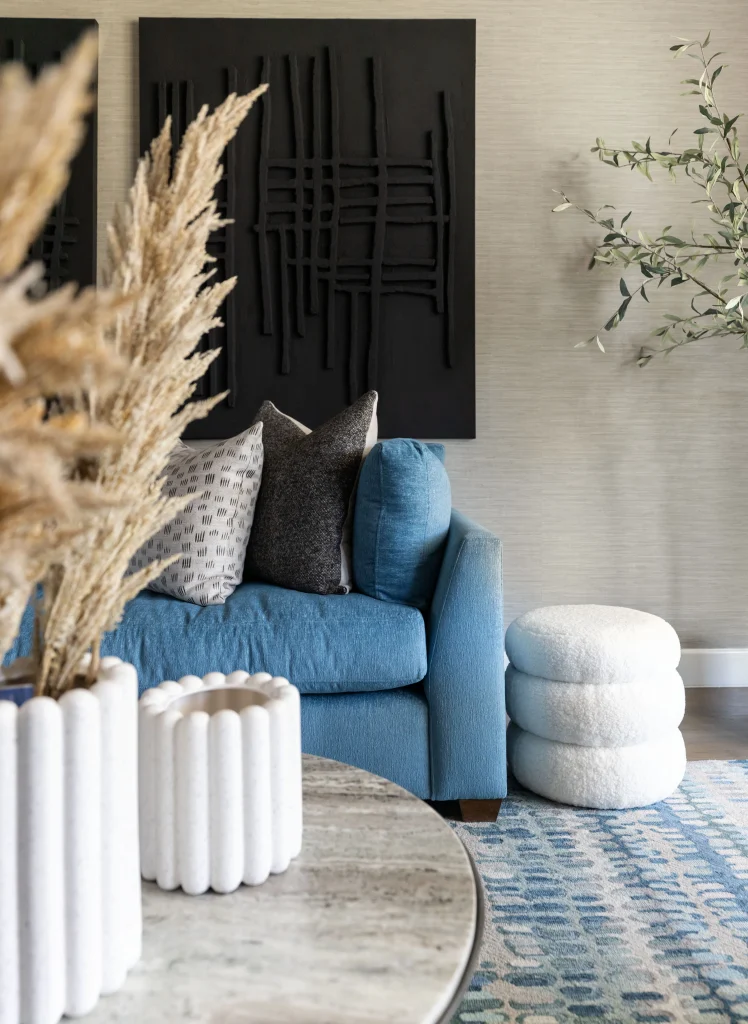 Blue sofa with pillows and white pouf