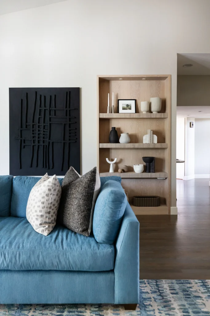 Blue sofa with pillows and wooden shelves