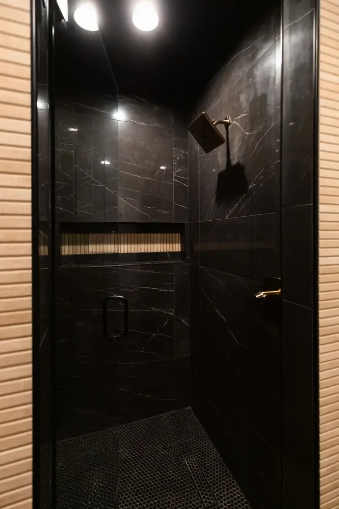 Shower with black marble tiles and gold rain shower head