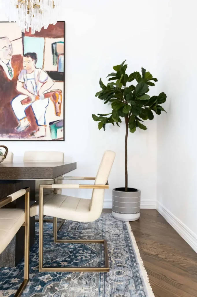 Dining area with white chairs and blue patterned rug