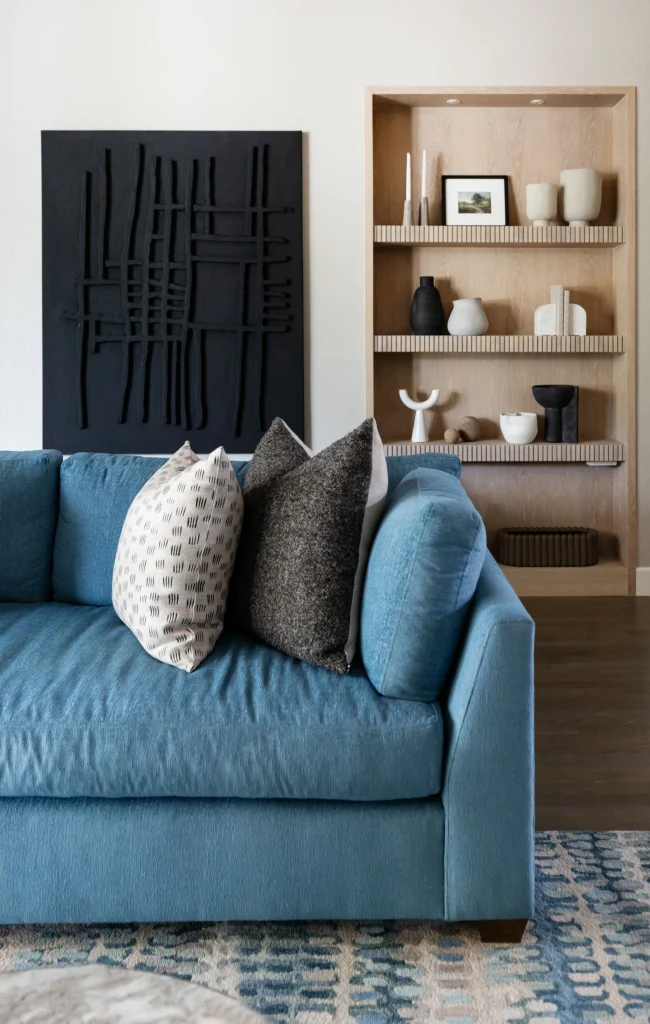 Blue sofa with pillows and wooden shelves