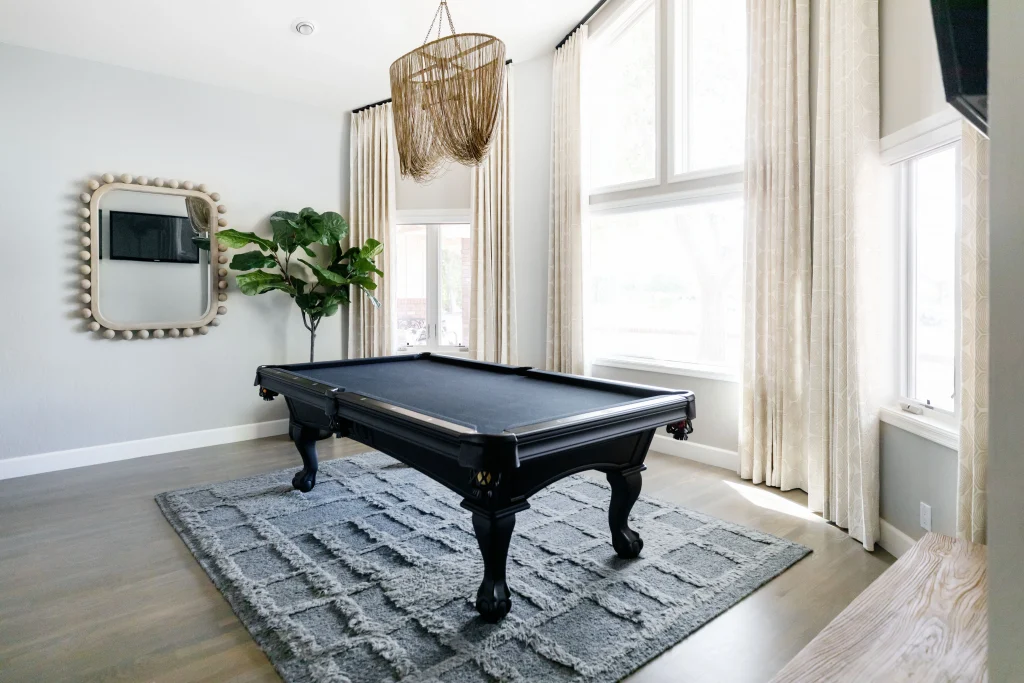 Black pool table in bright game room
