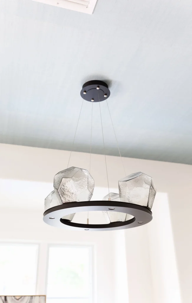 Modern circular chandelier with textured glass shades hanging from ceiling