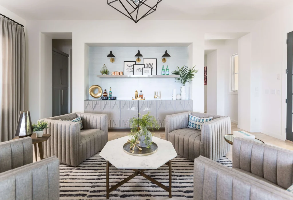 Living room with four gray armchairs around a marble coffee table
