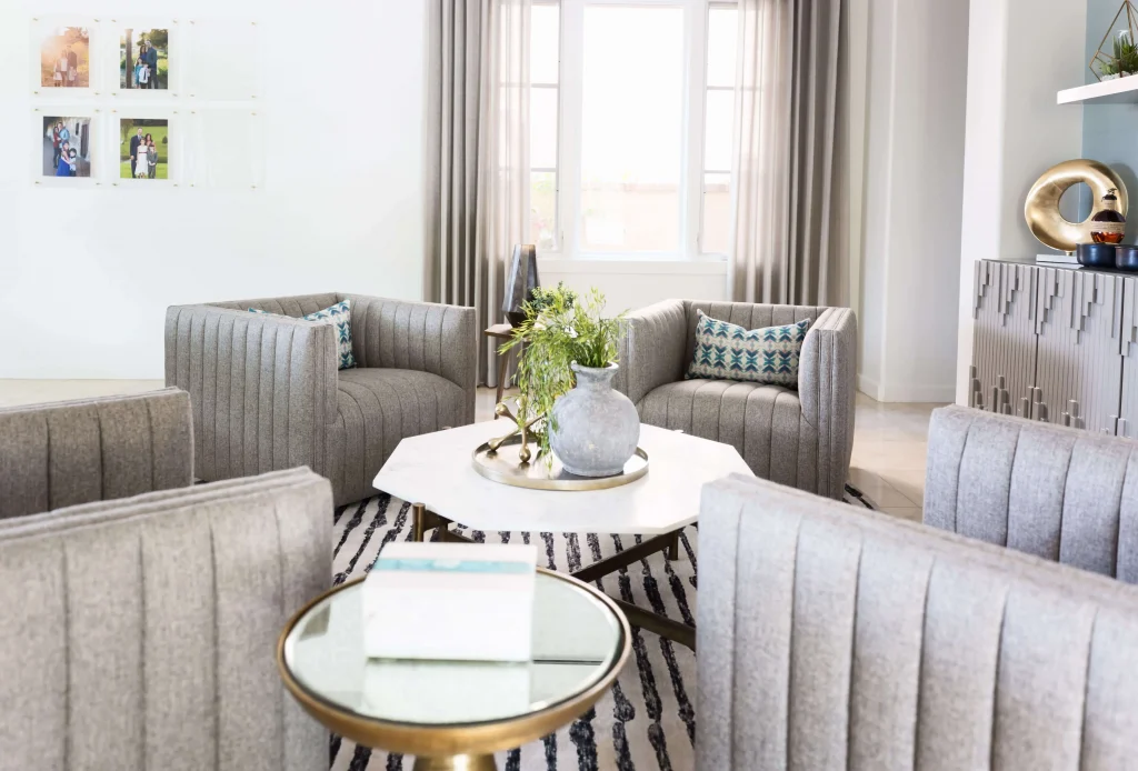 Luxury living room with gray upholstered armchairs around a white hexagonal coffee table