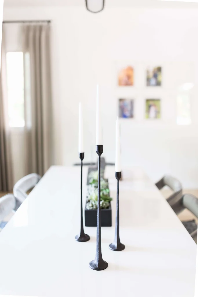 Dining table with tall black candleholders and succulent centerpiece