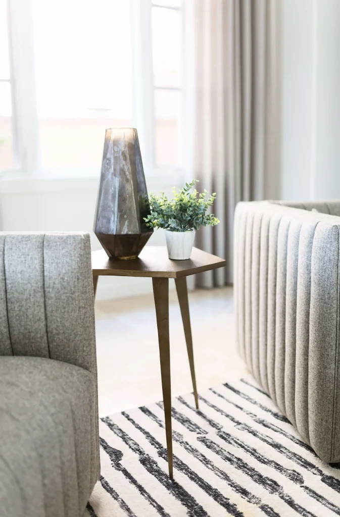 Gold side table with a sculptural lamp and small potted plant
