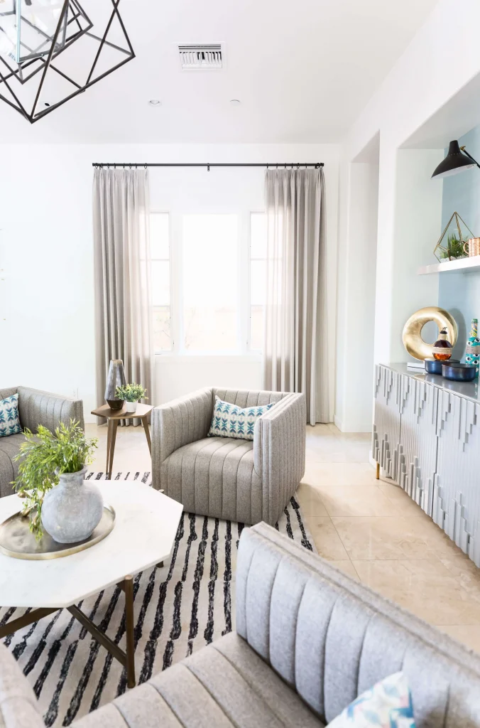 Bright living room with gray upholstered chairs and a white marble coffee table