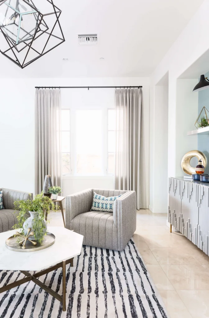 Bright modern living room with gray upholstered chairs and striped rug