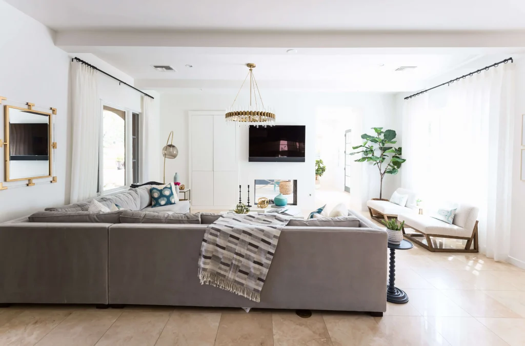 Bright modern living room with large gray sectional sofa and wall-mounted TV