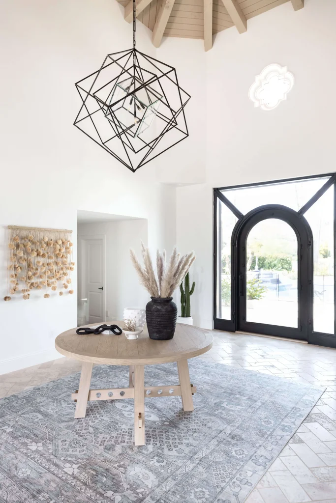 Entryway with round table, black vase, and geometric light