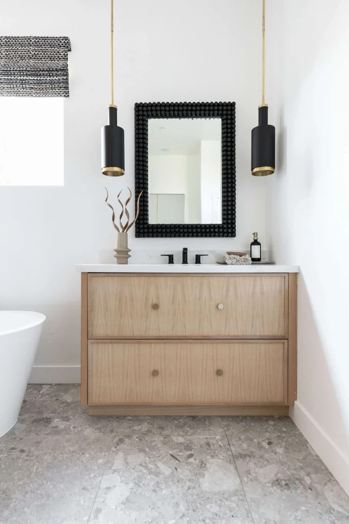 Wood vanity with black mirror and pendant lights