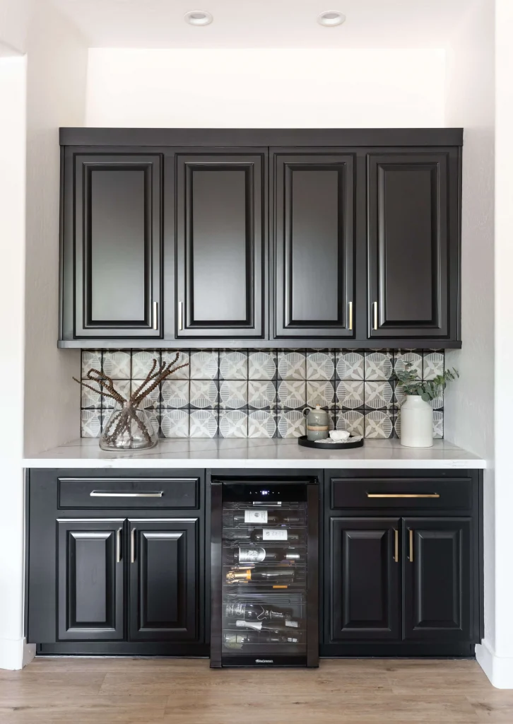 Black kitchen cabinets with patterned tile backsplash and wine cooler