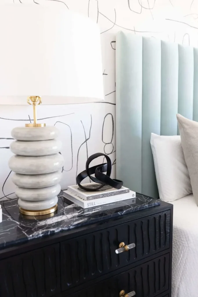 Nightstand detail with ceramic lamp and abstract decor