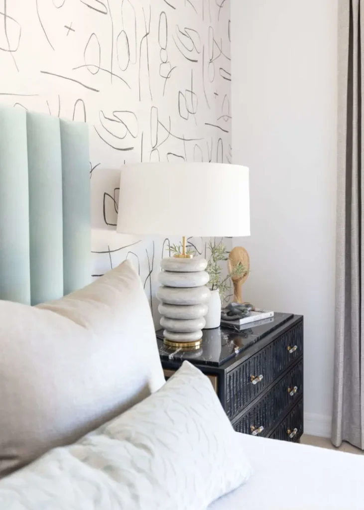 Cozy bedroom corner with a light blue headboard and black nightstand