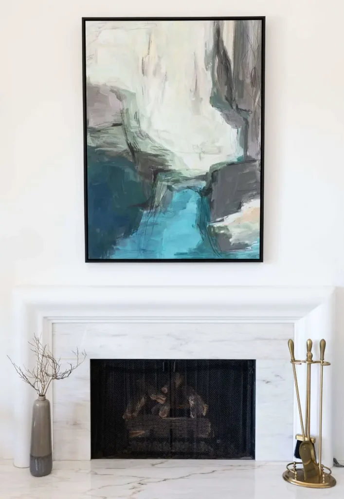 Abstract painting above white marble fireplace with black screen
