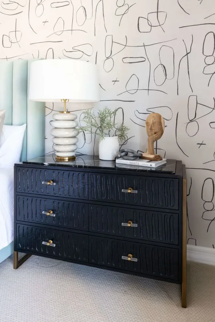 Black nightstand with lamp and abstract decor