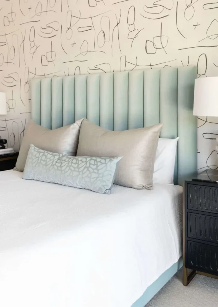 Bedroom with vertical tufted headboard and abstract wallpaper