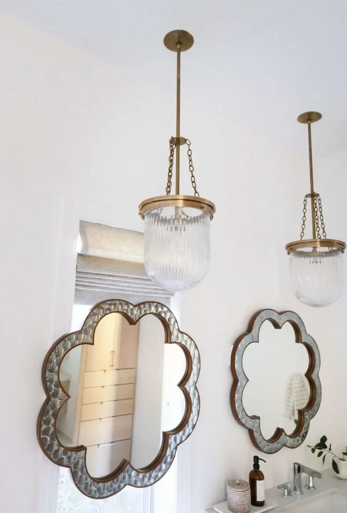 Close-up of flower-shaped mirrors and pendant lights in bathroom