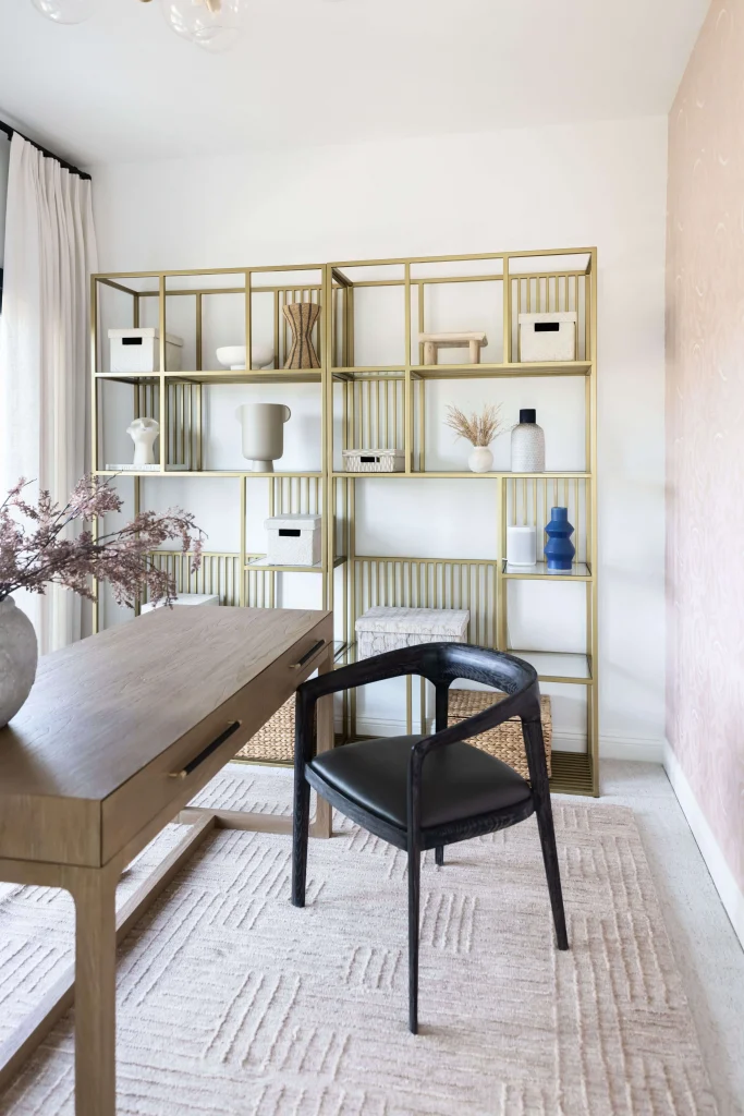Home office with wood desk and open brass shelving