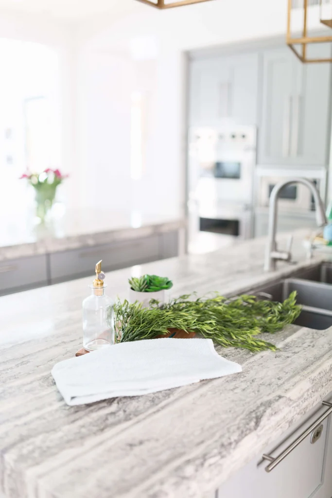 Marble kitchen island with herbs, towel, and soap bottle