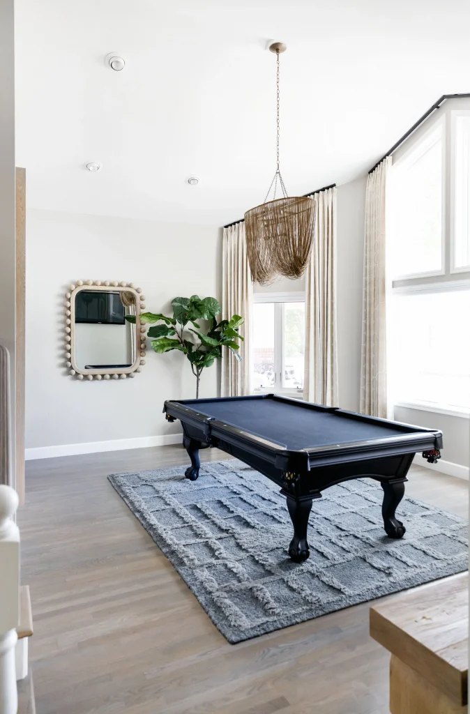 Black pool table in sunlit room