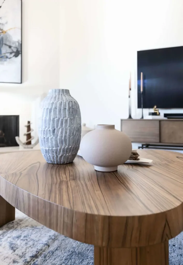 Two decorative vases on a wooden coffee table in a living room