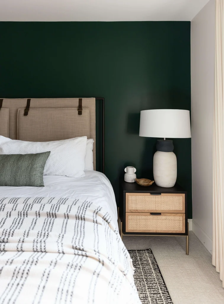 Modern bedroom with green wall and rattan headboard