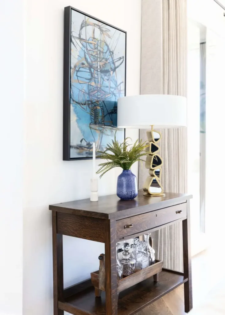 Wooden console table with bar accessories and modern lamp