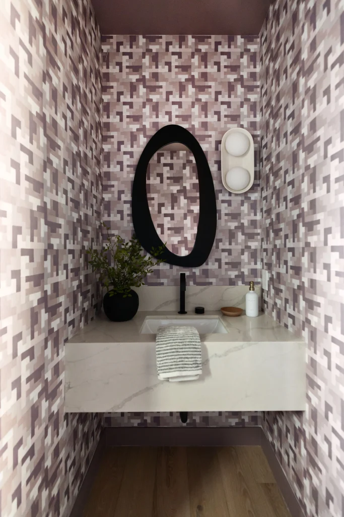 Powder room with geometric tile and oval mirror