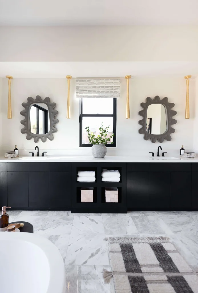 Bathroom with black cabinetry and two decorative mirrors