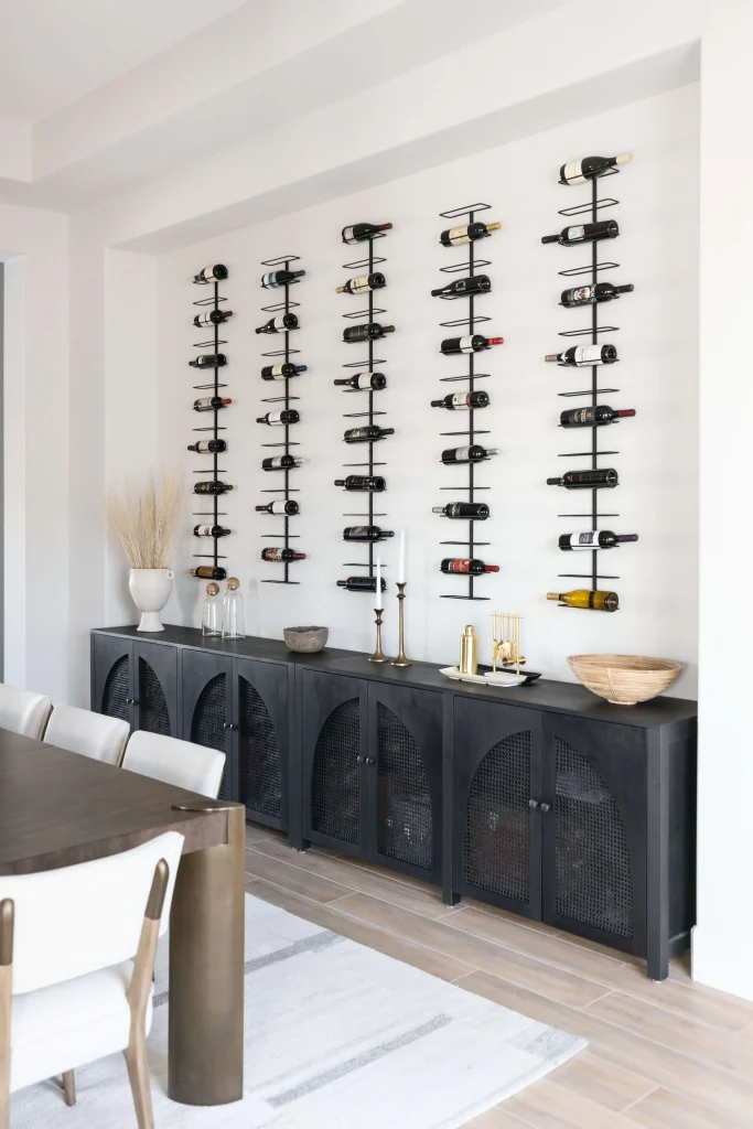Wine bottles displayed on wall racks above cabinet