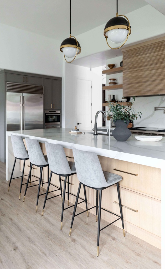 Sleek kitchen with gray bar stools and brass details