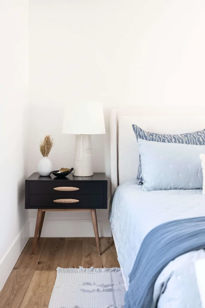Black nightstand with lamp and vase
