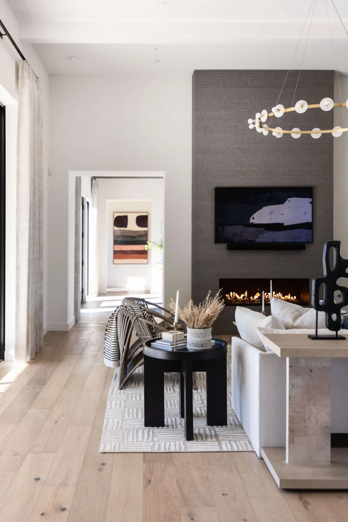 Gray sofa in living area with chandelier and fireplace