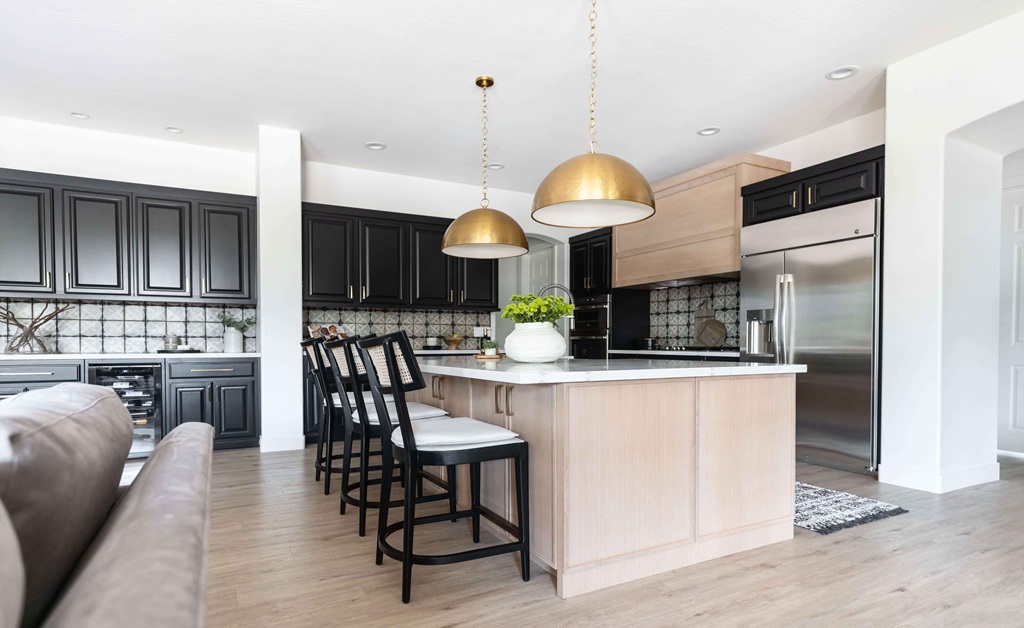 Modern kitchen with black cabinets and brass pendant lights
