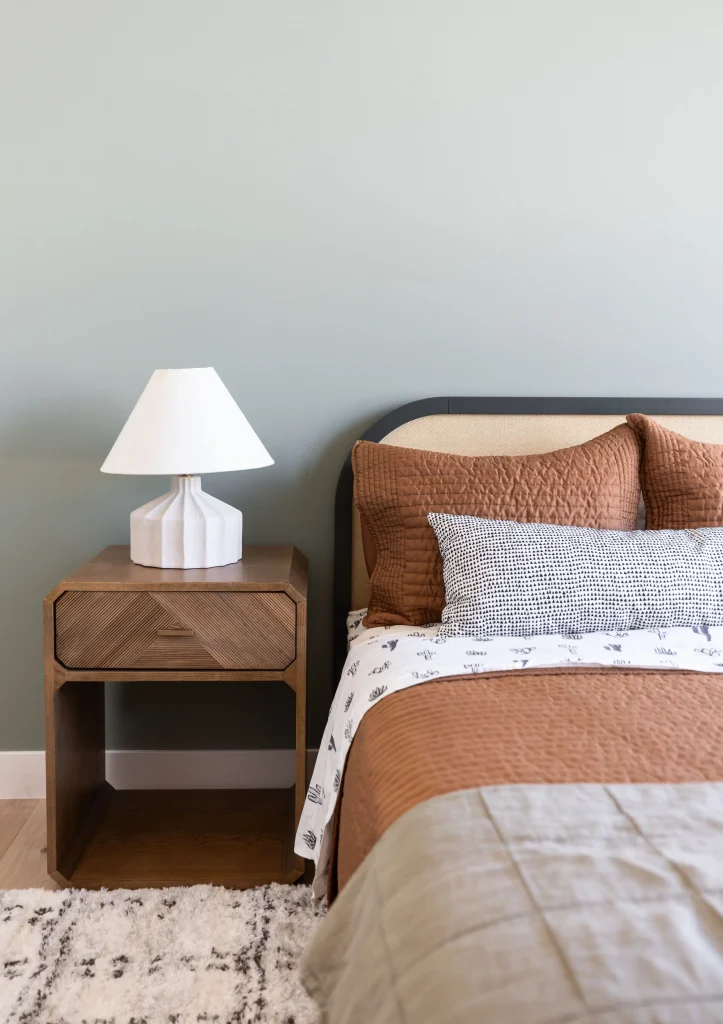 Cozy bed with wood nightstand and lamp