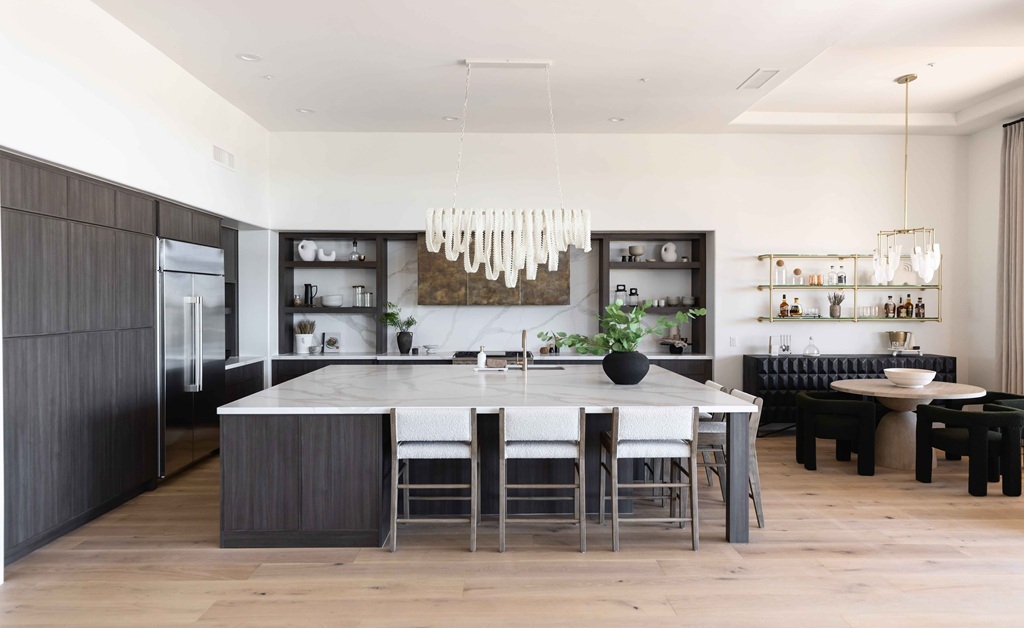Dark wood kitchen with white island and chairs.