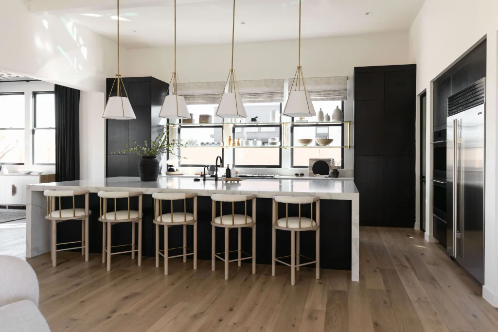 Black and white kitchen with pendant lights and bar stools