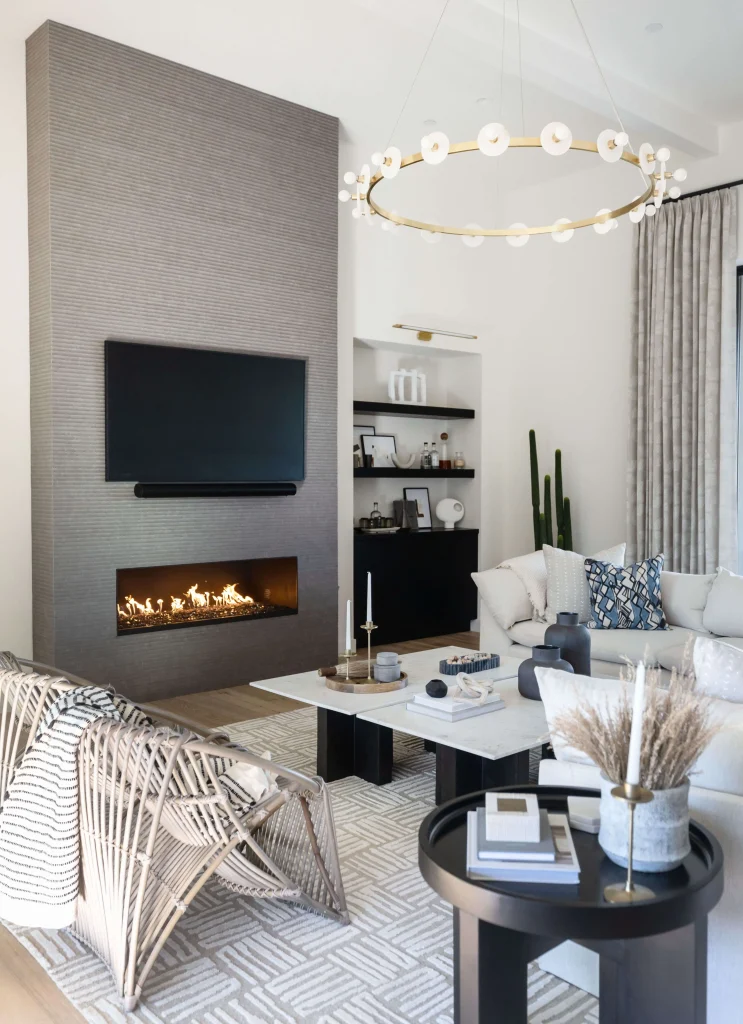 Modern living room with fireplace, woven chair, and coffee table decor