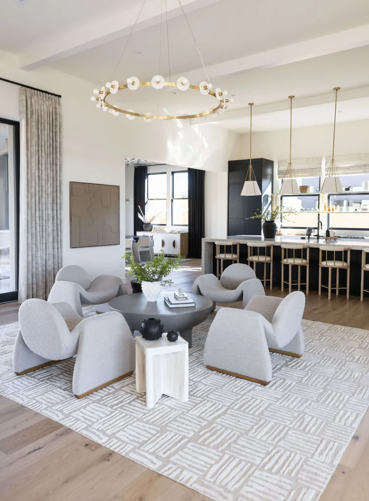 Spacious living and dining room with round chandeliers and gray seating