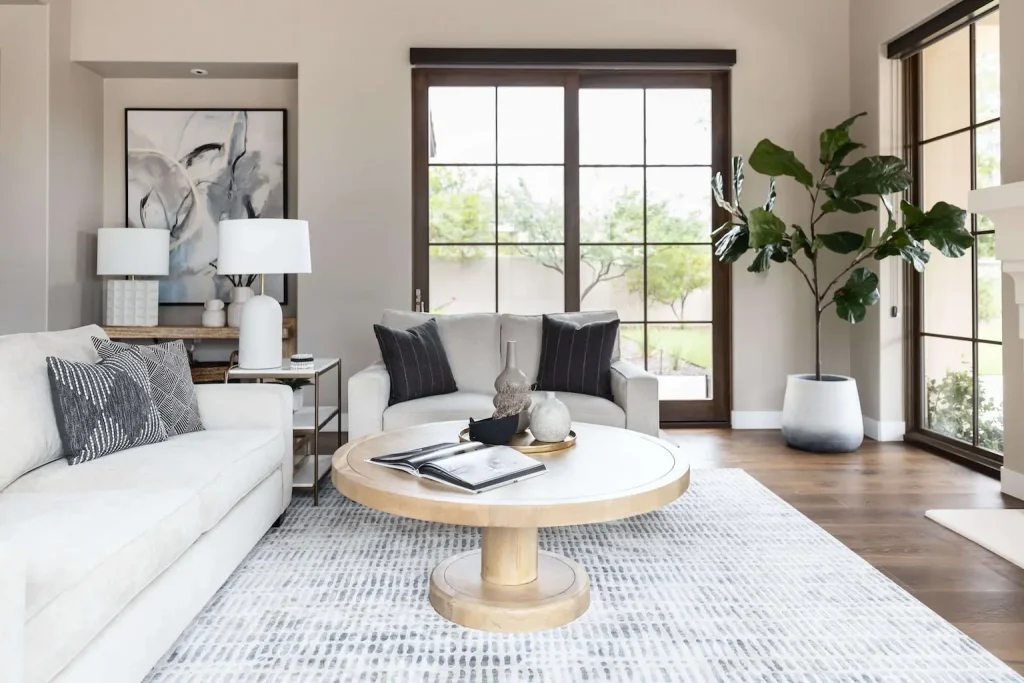 Bright living room with white sofas and large glass doors