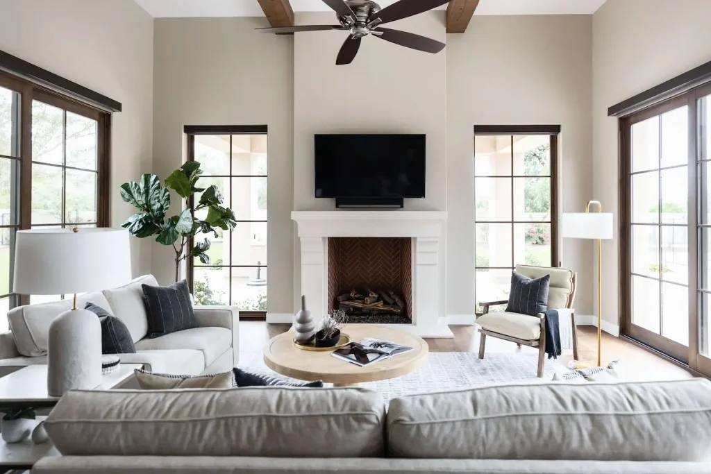 Bright living room with fireplace, TV, and neutral sofas