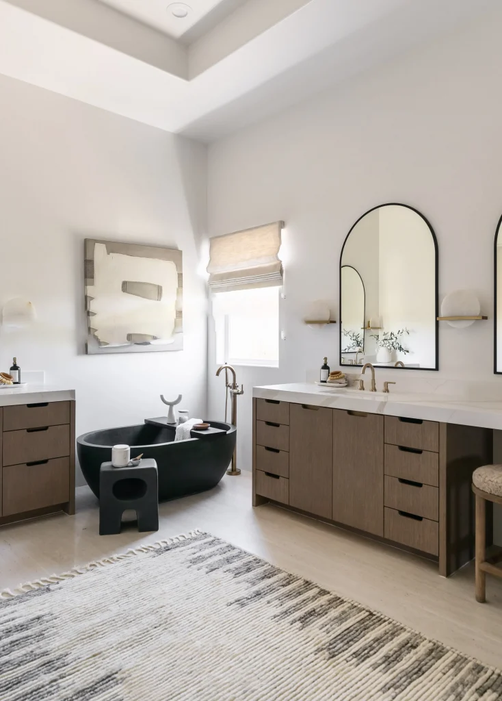 Bathroom with black tub and double vanity