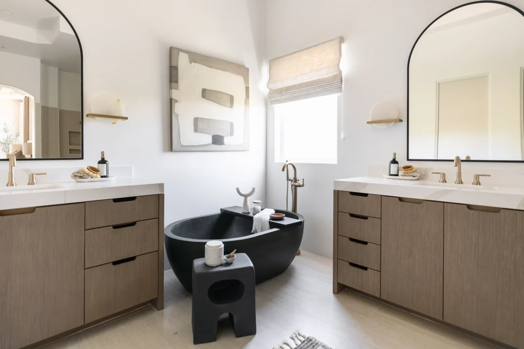 Bathroom with two vanities and a central black tub